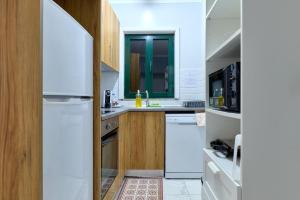a kitchen with white appliances and wooden cabinets at Plaza House Ílhavo in Ílhavo
