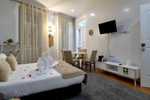 a bedroom with a bed and a table with chairs at Plaza House Ílhavo in Ílhavo