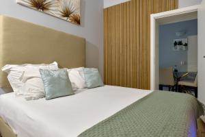 a bedroom with a bed with white sheets and pillows at Plaza House Ílhavo in Ílhavo +45 photos