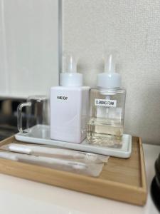 two bottles ofodorizers on a wooden tray on a counter at ゲストハウスHayatamaわびさび in Shingū +25 photos