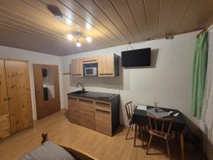 a kitchen with a table and a kitchen with a dining room at Zum Bergbauern in Waidhaus