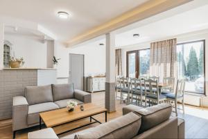 a living room with two couches and a table at Margareta Apartments in Odorheiu Secuiesc