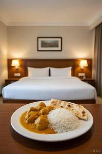 a plate of food on a table in a hotel room at Hotel Shivaay Inn in Kānpur