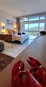 a bedroom with a bed and two red animal statues on the floor at tiki tides in Umdloti +29 photos