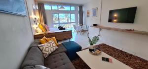a living room with a couch and a tv at tiki tides in Umdloti