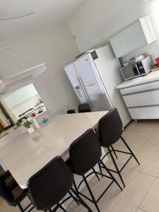 a kitchen with a table with four chairs and a refrigerator at דירה 9 in Eilat