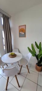 a white dining room with a white table and chairs at tiki tides in Umdloti
