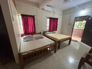 a small bedroom with two beds and a window at Eden homes in Honāvar