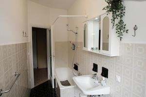 a white bathroom with a sink and a mirror at Vesta in Gargnano