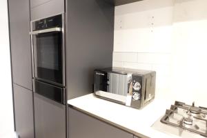a kitchen with a toaster oven and a microwave at 4 bedroom, Sleeps 12, Free Parking in Corby and Weldon +15 photos