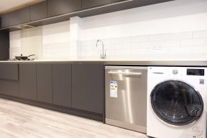 a kitchen with a washing machine and a sink at 4 bedroom, Sleeps 12, Free Parking in Corby and Weldon