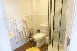 a white bathroom with a toilet and a shower at 4 bedroom, Sleeps 12, Free Parking in Corby and Weldon