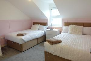a bedroom with two beds and a window at 4 bedroom, Sleeps 12, Free Parking in Corby and Weldon