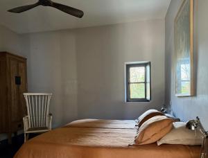 a bedroom with a large bed with a ceiling fan at Le Pavillon Du Regisseur in Val-de-Dagne