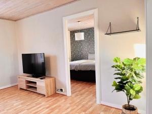 a living room with a television and a bedroom at Homey Stay in Halmstad