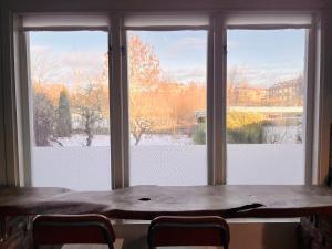 a table with chairs in front of a large window at Homey Stay in Halmstad +4 photos