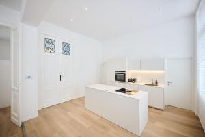 a kitchen with white cabinets and a white counter at Louise City 2 in Brussels