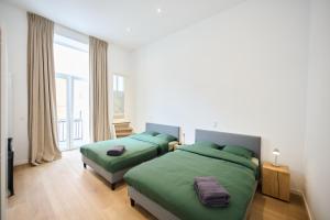 a bedroom with two beds and a large window at Louise City 2 in Brussels