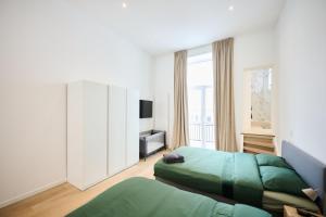 a bedroom with two green beds and a television at Louise City 2 in Brussels