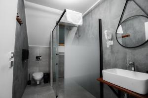 a bathroom with a sink and a toilet and a mirror at Pensiunea 82 in Nădlac +33 photos