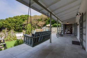 a porch of a house with a swing at The Oyster Shack by The Oyster Collection in Kenton on Sea