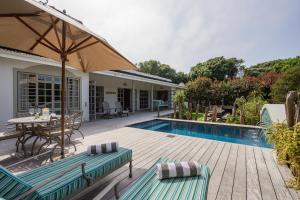 a patio with a table and chairs and a swimming pool at The Oyster Shack by The Oyster Collection in Kenton on Sea