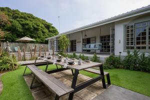 a table and benches in a yard with a house at The Oyster Shack by The Oyster Collection in Kenton on Sea