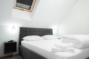 a white bed with white sheets and pillows on it at Pensiunea 82 in Nădlac