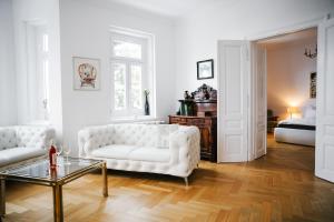 a white living room with a couch and a table at Golf Apartment Villa Elisabeth in Mariánské Lázně