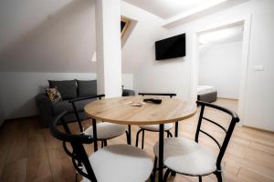 a dining room with a wooden table and chairs at Pensiunea 82 in Nădlac