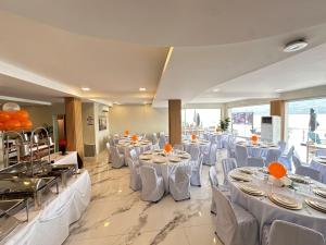 a banquet hall with white tables and white chairs at Costa Del Subic in Subic