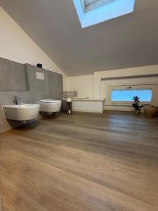 a large bathroom with two sinks and a skylight at Beato Mario Apartments in Tirano
