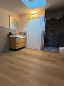 a bathroom with a white door and a sink at Beato Mario Apartments in Tirano