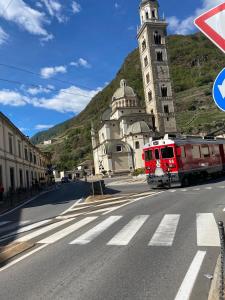 a train on a street in front of a church at Beato Mario Apartments in Tirano +10 photos