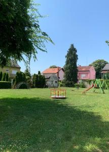 a park with a playground in the grass at Apartman Loni , Belišće in Belišće