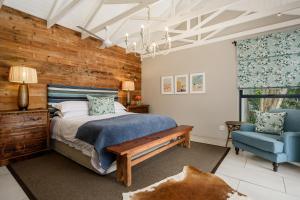 a bedroom with a bed and a blue chair at Ocean Breeze by The Oyster Collection in Kenton on Sea +24 photos