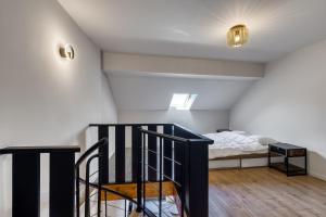a staircase leading to a bedroom with a bed at Duplex design avec balcon I Hyper centre Thonon in Thonon-les-Bains