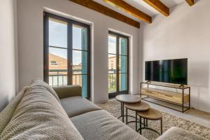 a living room with a couch and a flat screen tv at Duplex design avec balcon I Hyper centre Thonon in Thonon-les-Bains