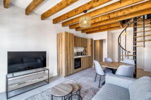 a living room with a tv and a table and chairs at Duplex design avec balcon I Hyper centre Thonon in Thonon-les-Bains