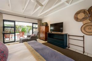 a bedroom with a bed and a flat screen tv at Ocean Breeze by The Oyster Collection in Kenton on Sea