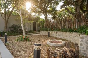 a garden with a fire pit in a yard with trees at Ocean Breeze by The Oyster Collection in Kenton on Sea