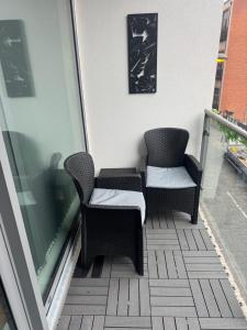 two chairs sitting on the balcony of a building at 2 Bedroom Apartment - Henry St Central Liverpool in Liverpool
