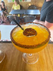 a drink sitting on a table with an orange at Naniqui Cottage - Only Adults -Parking Golf Car Only-No Electric Bikes in Culebra