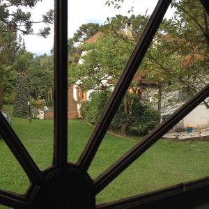 Blick auf einen Hof aus einem Fenster in der Unterkunft Passarim Chalé in Monte Verde