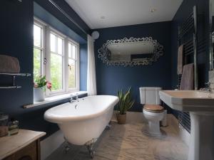a bathroom with a tub and a sink and a toilet at 5 Bed in Devizes oc-s34742 in Devizes +17 photos