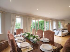 a dining room with a table with plates and flowers on it at 5 Bed in Devizes oc-s34742 in Devizes