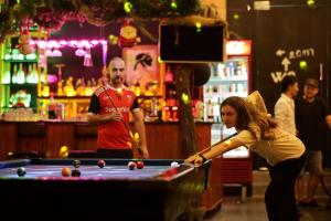 a woman playing a game of pool in a bar at Bee Backpackers Hostel in Quang Binh