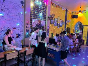 a group of people standing around a bar in a restaurant at Bee Backpackers Hostel in Quang Binh