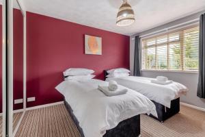 two beds in a room with a red wall at 2 Bed in Wool oc-r29949 in Wool