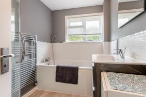 a bathroom with a tub and a sink and a shower at 2 Bed in Wool oc-r29949 in Wool +13 photos